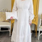 Front view of woman wearing long white LDS temple dress with gathered waist